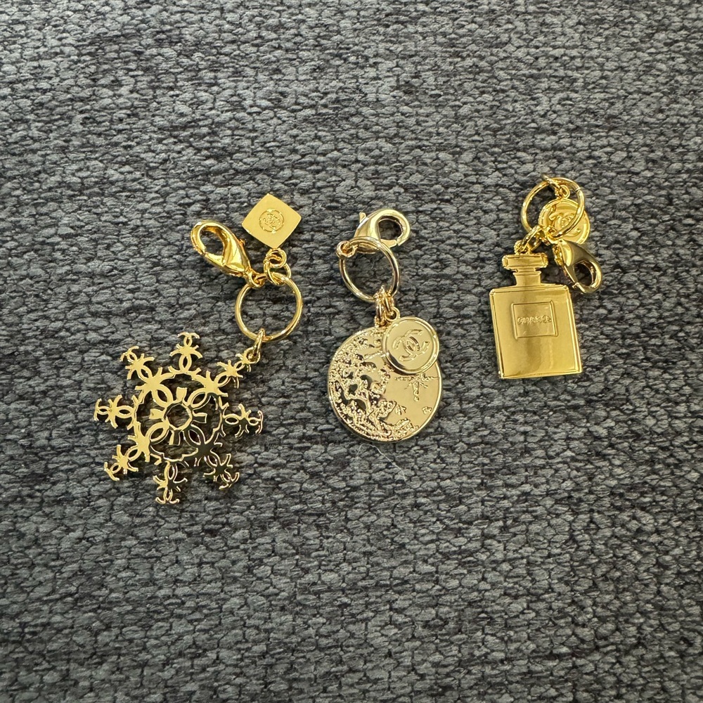 Black Chanel cosmetics bag with 3 Chanel charms.